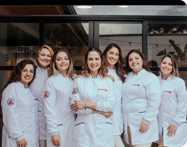Foto de equipe de profissionais da Plano A reunidas em uma mesa