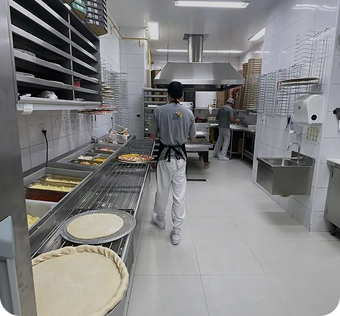 Imagem de uma cozinha de pizzaria com tudo organizado